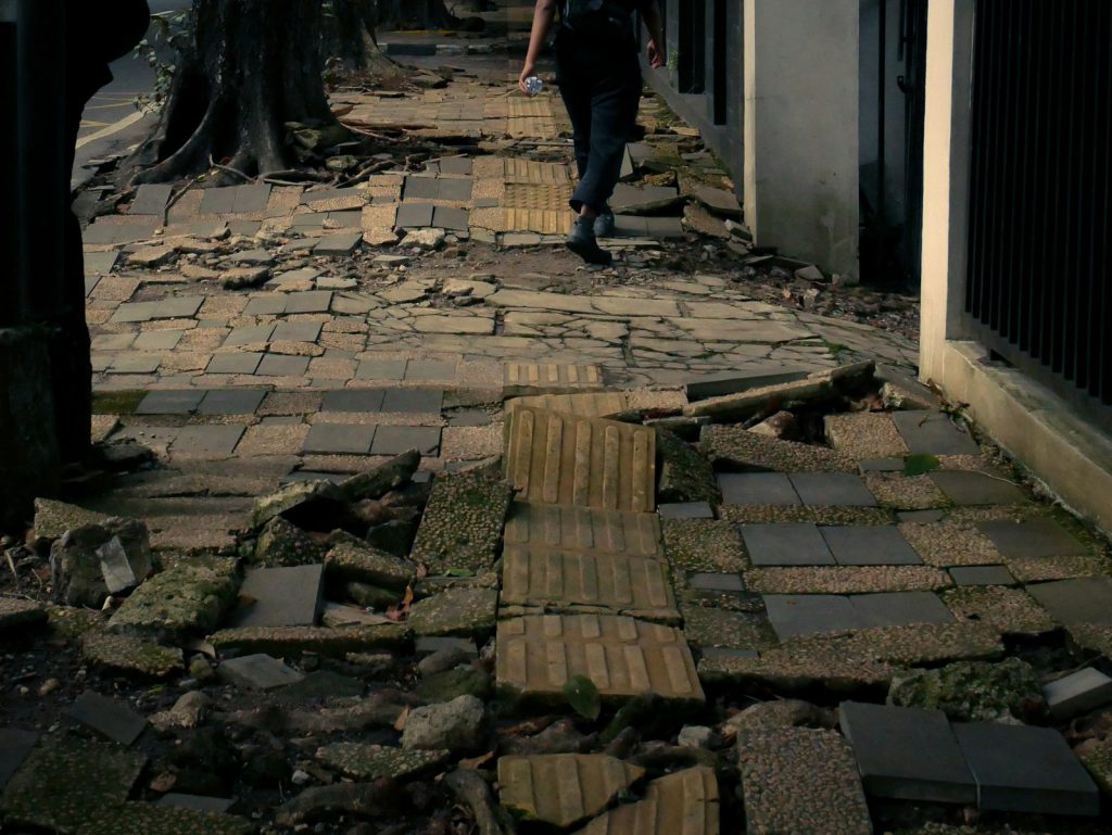 Trip and Fall Accident Lawyer in Bellerose – person walking on a broken sidewalk